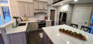 Kitchen remodel with gray shaker cabinets, white quartz countertops, stainless steel appliances, and a large island